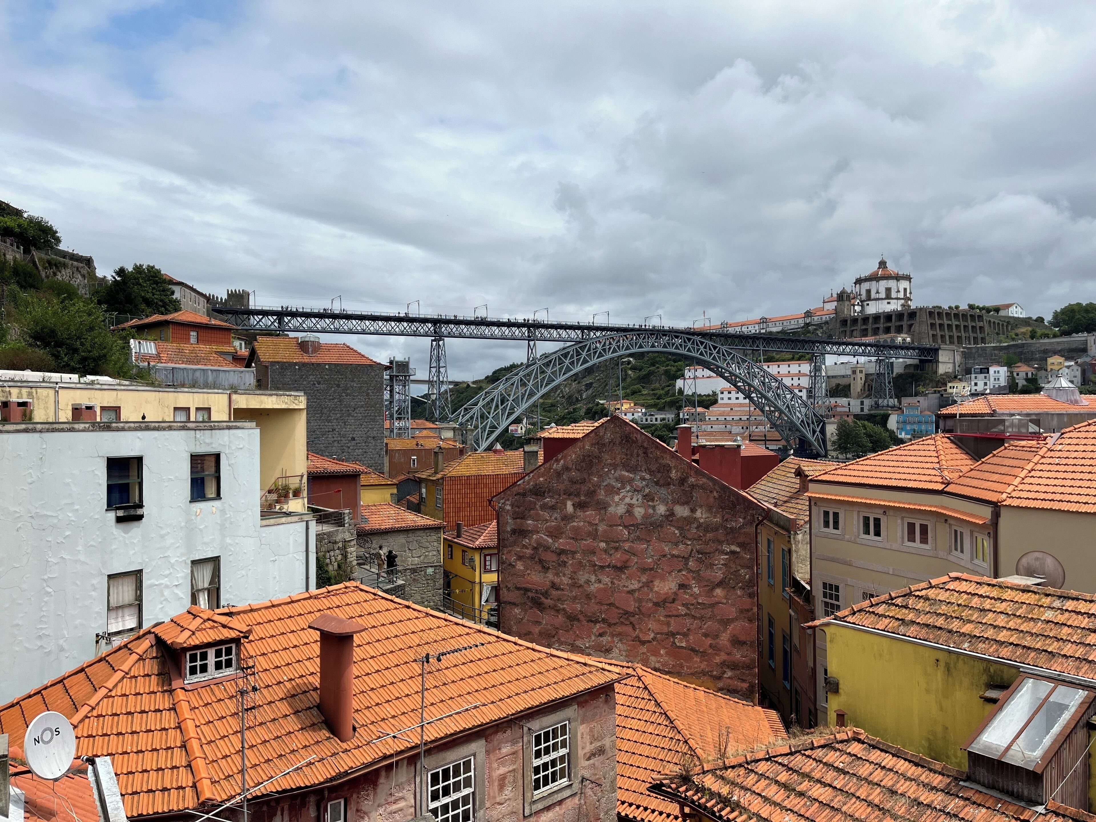 Une ville historique, avec ses bâtiments traditionnels, un pont remarquable et, au loin, une structure qui ressemble à un château.