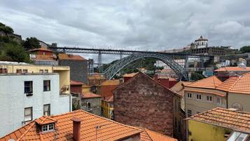 A historic town with traditional buildings, a prominent bridge, and a castle-like structure in the background.