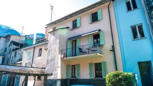 A multi-story building with balconies, a pergola, and a small garden area. - Apartment in Vallemaggia Cevio (Cevio)