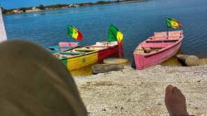 Una hilera de botes coloridos amarrados en aguas tranquilas, con un cielo despejado al fondo.