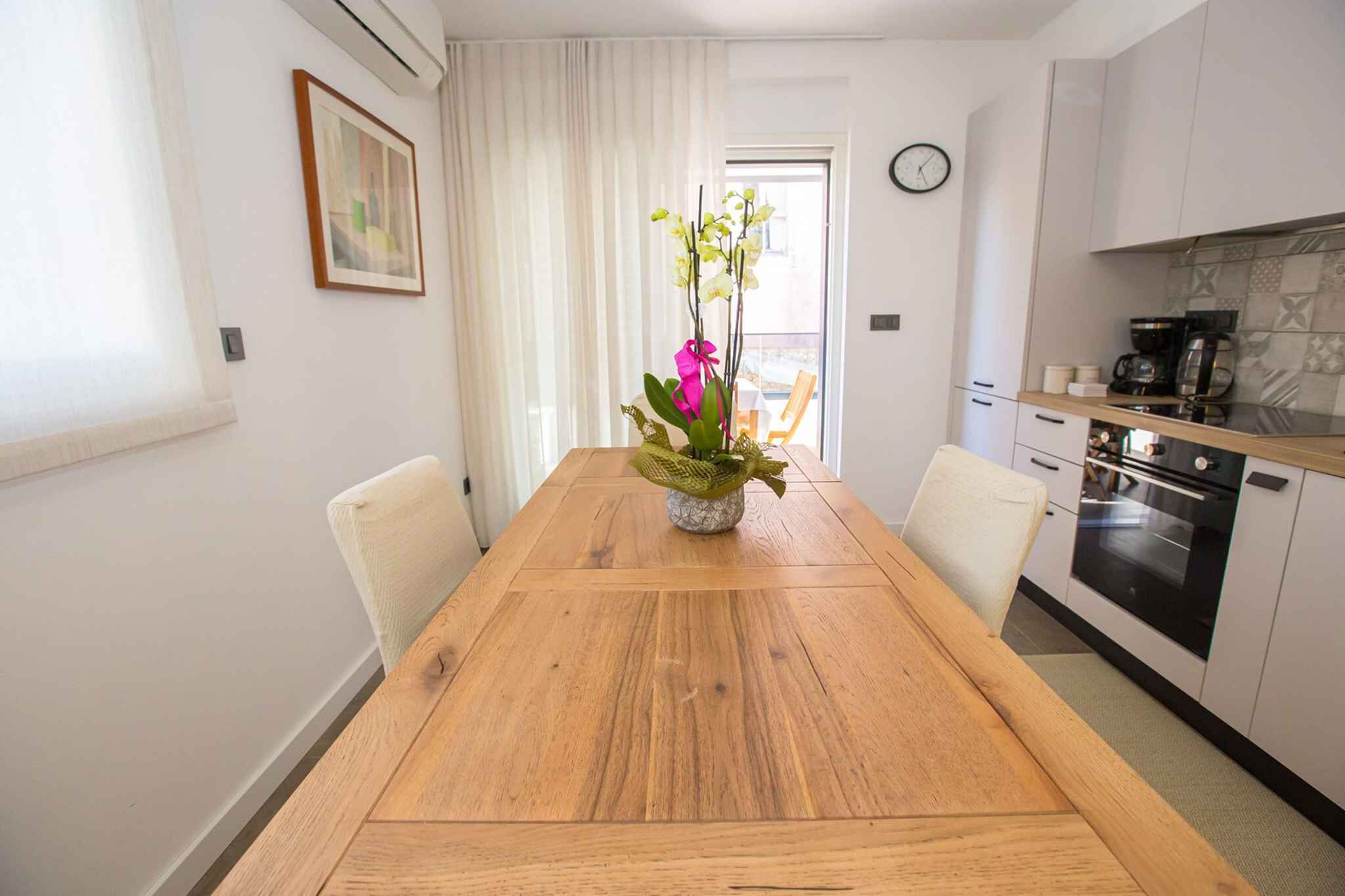 En matplats med ett träbord, stolar och en vas med blommor.