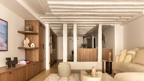 Een moderne woonkamer met een houten kast, een ronde salontafel en een beige bank.