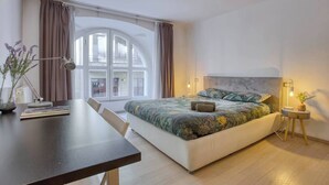 A modern bedroom with a large bed, a desk, and a window with curtains. - DUOMO 10min - Lovely flat in the center (Milano)