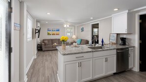 A modern kitchen with white cabinets, a granite countertop, and a dishwasher. - 2 Kitchens, 2 Living Rooms, Sleeps 10 (Surf City)