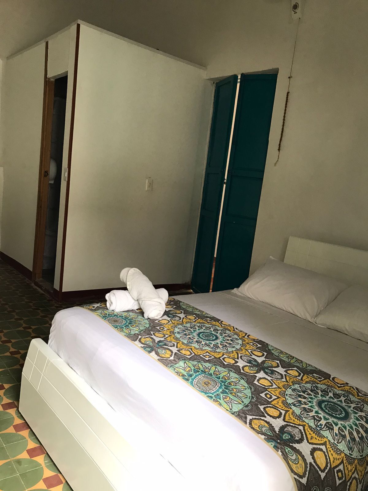 Une chambre d’hôtel avec un lit, une armoire et une porte.