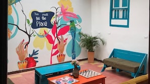 A cozy room with a mural, a chessboard, and a bench. - The Best Adventure (San Gil)