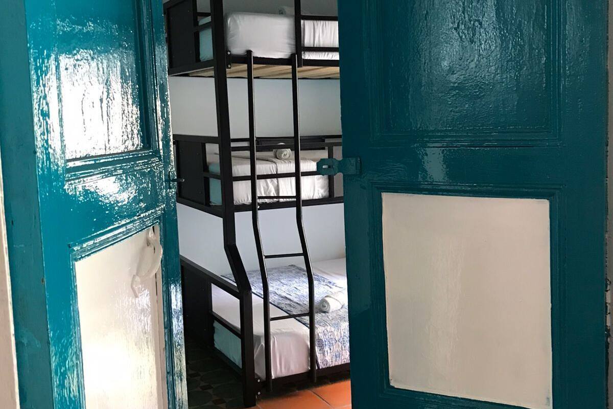 A room with bunk beds and a teal door.