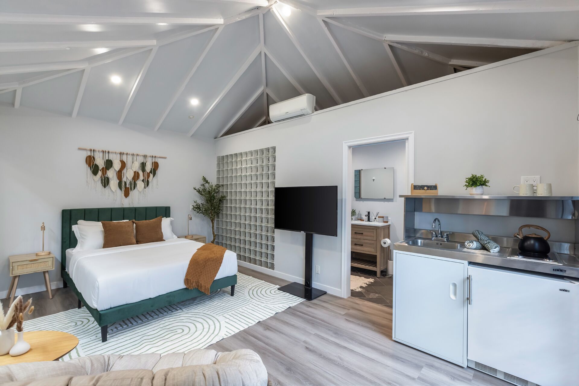Een moderne slaapkamer met een bed, nachtkastje en een televisie.
