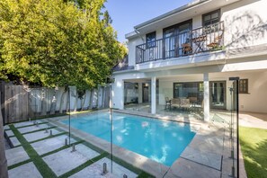 A modern house with a swimming pool, a covered patio, and a fenced backyard. - Casa Estrella by Oraklus (Los Angeles)