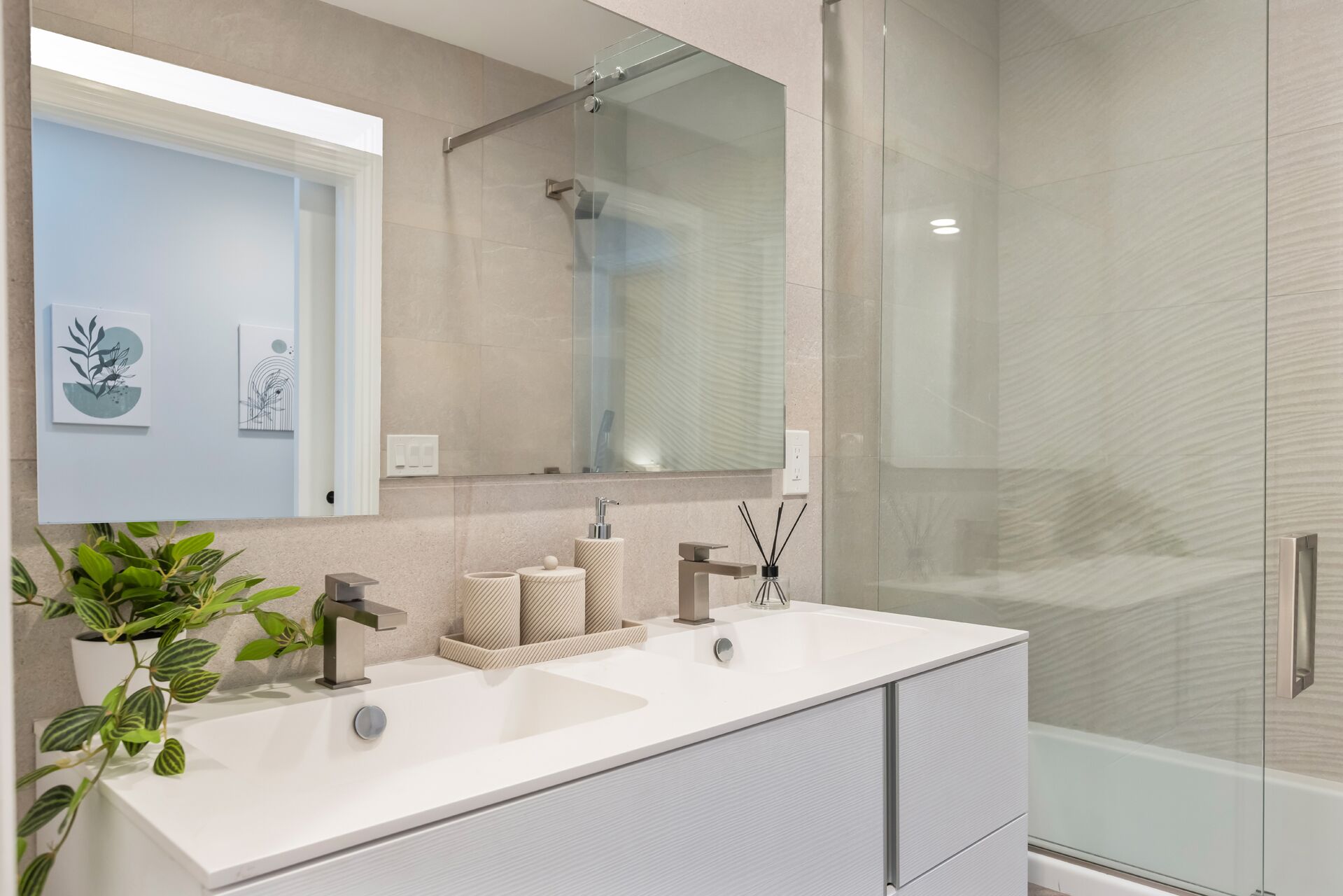 Une salle de bain moderne avec un meuble-lavabo blanc, une cabine de douche en verre et un grand miroir.