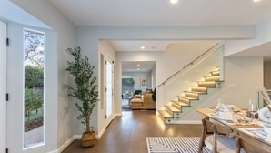 A modern interior with a staircase, dining area, and a view of the outdoors. - Casa Estrella by Oraklus (Los Angeles)