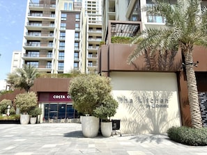 A modern building with a sign for 'The Kitchen by Spinneys' and a Costa Coffee shop.