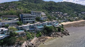 Une station balnéaire dotée de bâtiments modernes, d’une plage et bordée de montagnes.