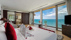 Une chambre d’hôtel avec un grand lit, une télévision et une vue sur l’océan.