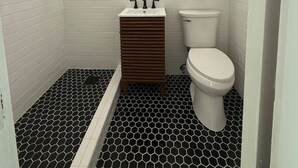 A small, compact bathroom with white tiled walls, a wooden vanity, a white toilet, and a black and white hexagonal floor pattern. - 203 Vintage Escape in a 1930s Gem (Klamath Falls)