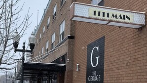 A brick building with a sign reading "111 Main" and a large "G The George" sign on the side. - 203 Vintage Escape in a 1930s Gem (Klamath Falls)