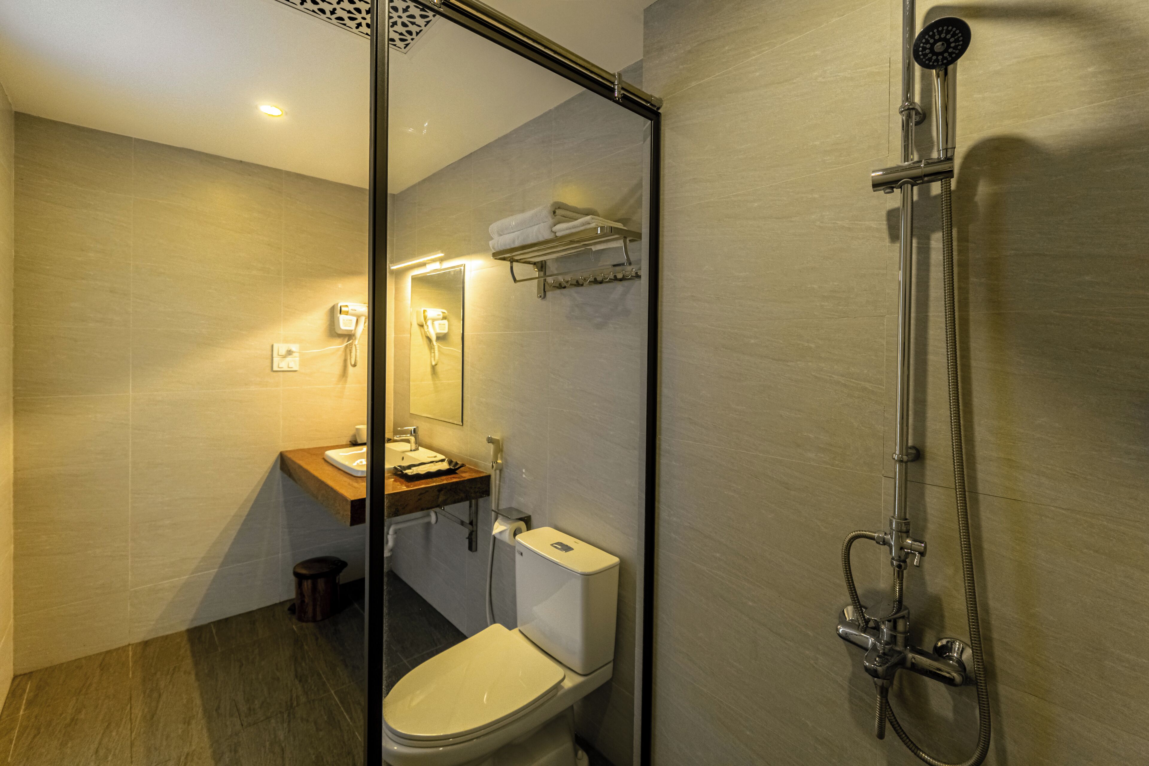Un baño moderno con inodoro, lavabo, espejo y ducha.