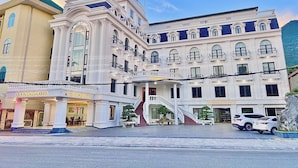A hotel with a grand entrance, multiple floors, and a staircase leading to the entrance. - An Khang Hotel (Ha Giang 1)