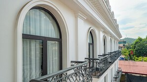 A building with arched windows and a balcony with wrought iron railings. - An Khang Hotel (Ha Giang 1)
