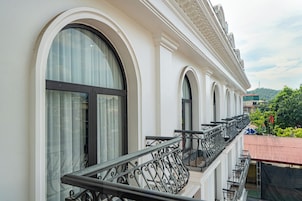 Un edificio con ventanas arqueadas y un balcón con barandilla de hierro forjado.