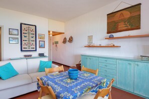 A dining area with a table set for two, a blue tablecloth, and a blue bowl.