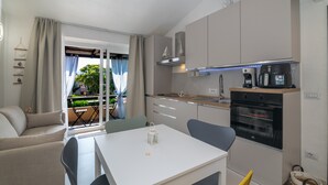 Een kleine keuken met een eethoek, een inbouwoven en uitzicht op de omgeving.