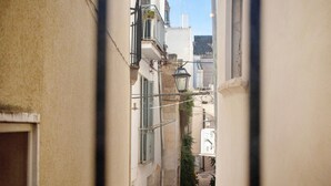 A narrow alleyway with buildings on either side, a street lamp, and a small plant. - Apartment 'Unità Due' with Shared Terrace, Wi-Fi, and Air Conditioning (Rutigliano)