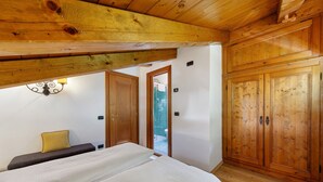 A wooden room with a bed, a bench, and a wardrobe. - Apartment 'Hilde' with Mountain View, Private Terrace and Wi-Fi (Peaio)