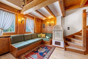 A wooden interior with a green sofa, a patterned rug, and a staircase. - Apartment 'Hilde' with Mountain View, Private Terrace and Wi-Fi (Peaio)