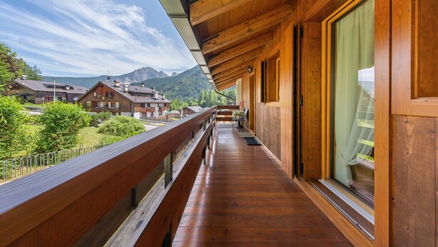 A wooden balcony with a view of mountains and other buildings. - Apartment 'Hilde' with Mountain View, Private Terrace and Wi-Fi (Peaio)