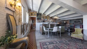 A spacious kitchen with a central island, white chairs, and a dining table. - Apartment 'La Fabriqueta Deluxe' with Mountain View, Wi-Fi and Air Conditioning (Riudecanyes)