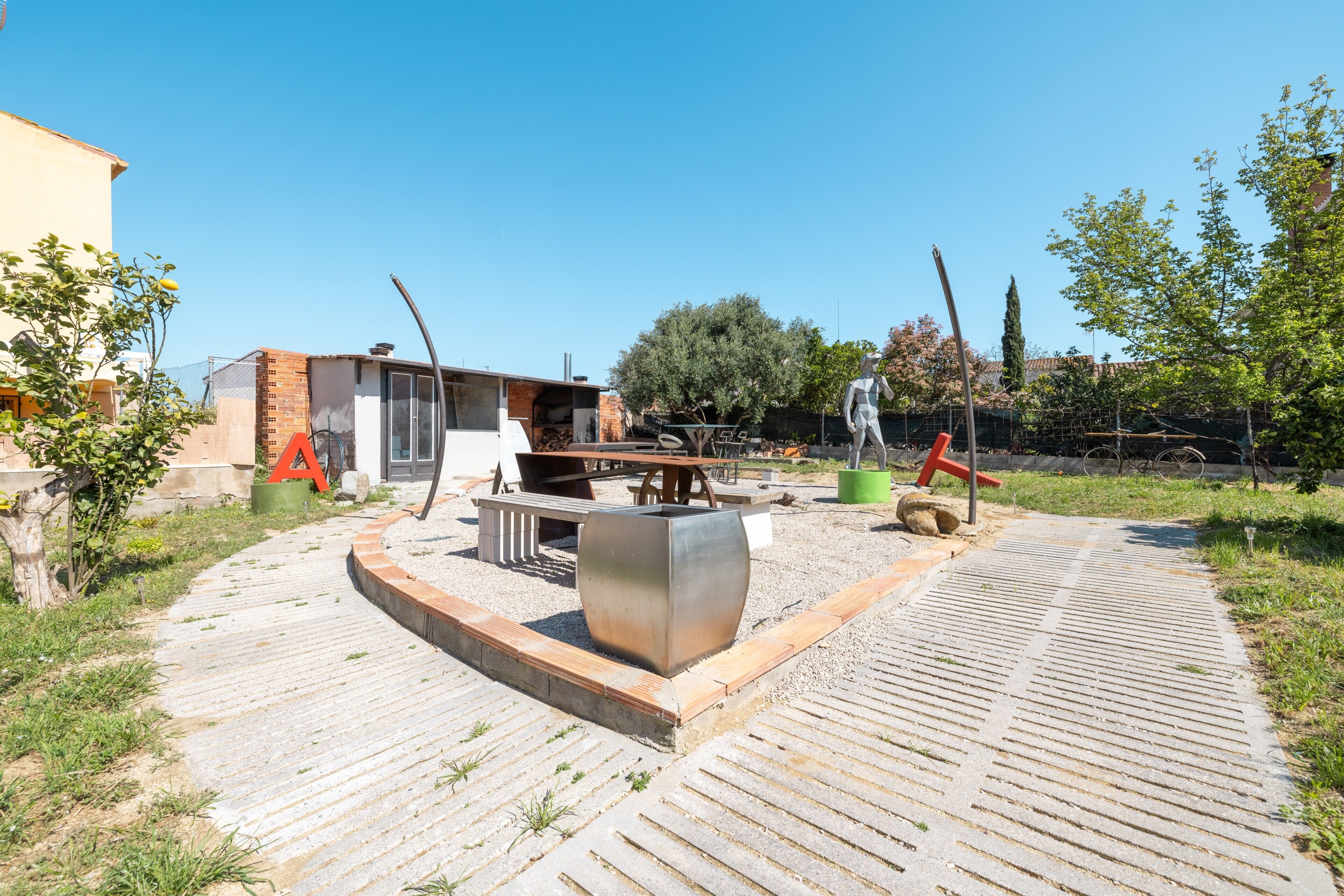 An outdoor patio area with a fire pit, seating, and a large planter.