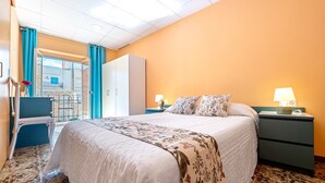 Hotellihuone, jossa on sänky, yöpöytä ja näkymä ulos.