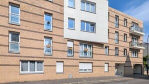 A multi-story residential building with a brick facade, multiple windows, and balconies.