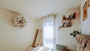 A bedroom with a bed, a ladder, a bookshelf, and a wall decoration.