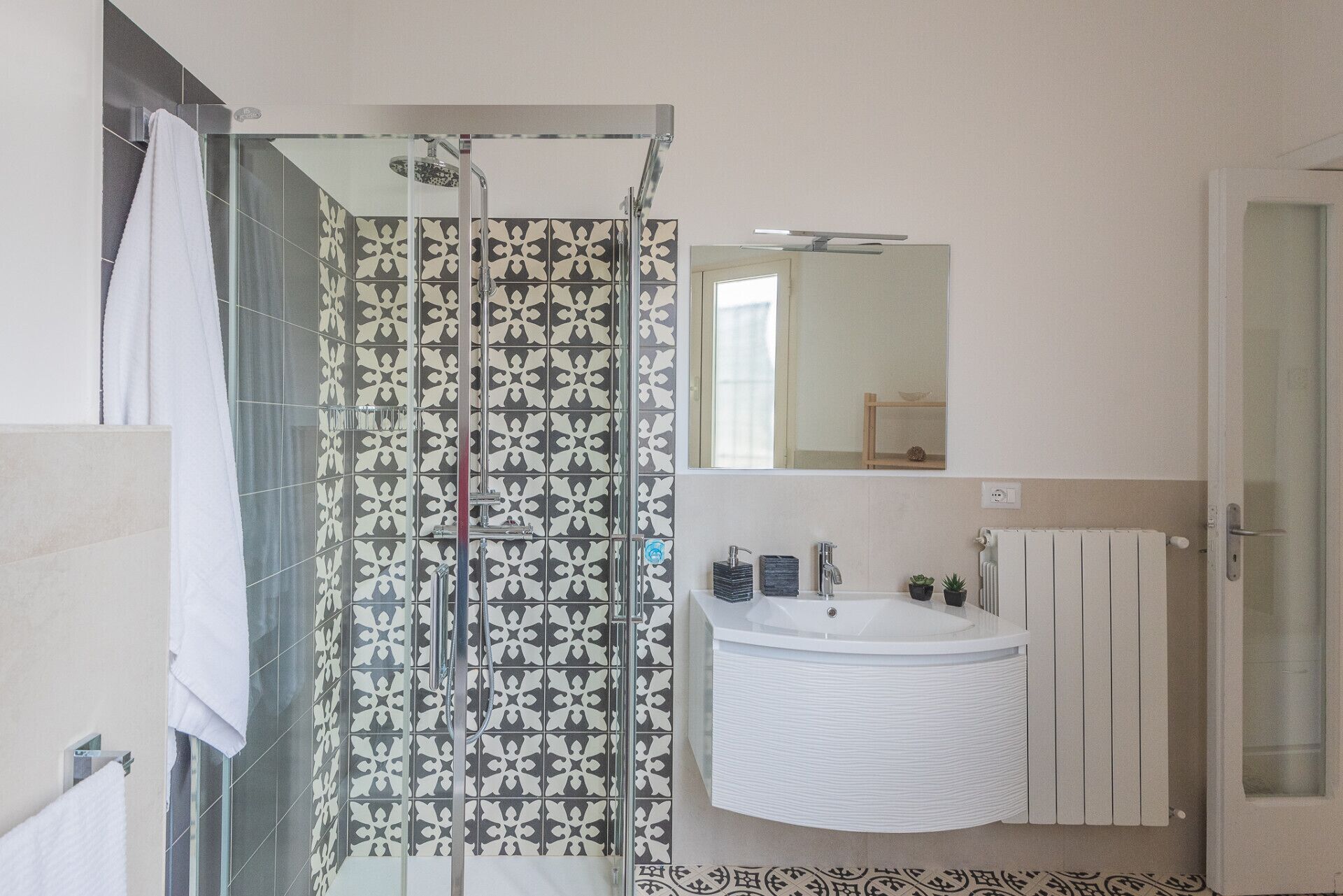 Un baño con ducha, lavamanos y espejo.