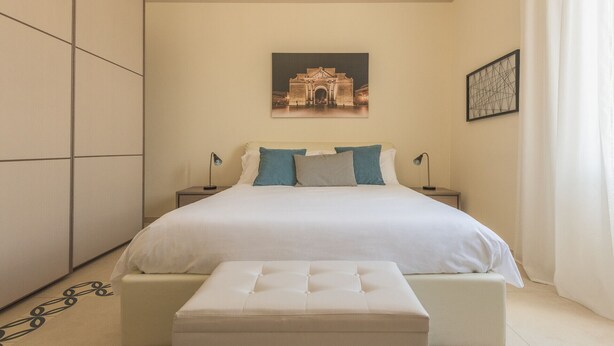 A bedroom with a large bed, two bedside tables, a wall-mounted picture, and a curtain. - Casa Mabel - Lecce Selection (Lecce)