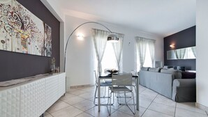 A modern living room with a dining area, a sofa, and a dining table with chairs.
