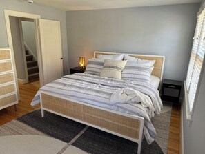 Ein Schlafzimmer mit Bett, Nachttischen, einer Lampe und einer Treppe.