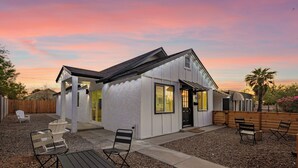 A modern house with a patio area featuring outdoor seating and a gravel ground. - Charming 3-bedroom house in welcoming Downtown Gilbert with WiFi, AC (Gilbert)