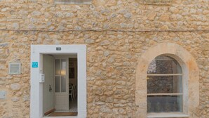 A stone building with a door labeled "ETV" and an arched window.