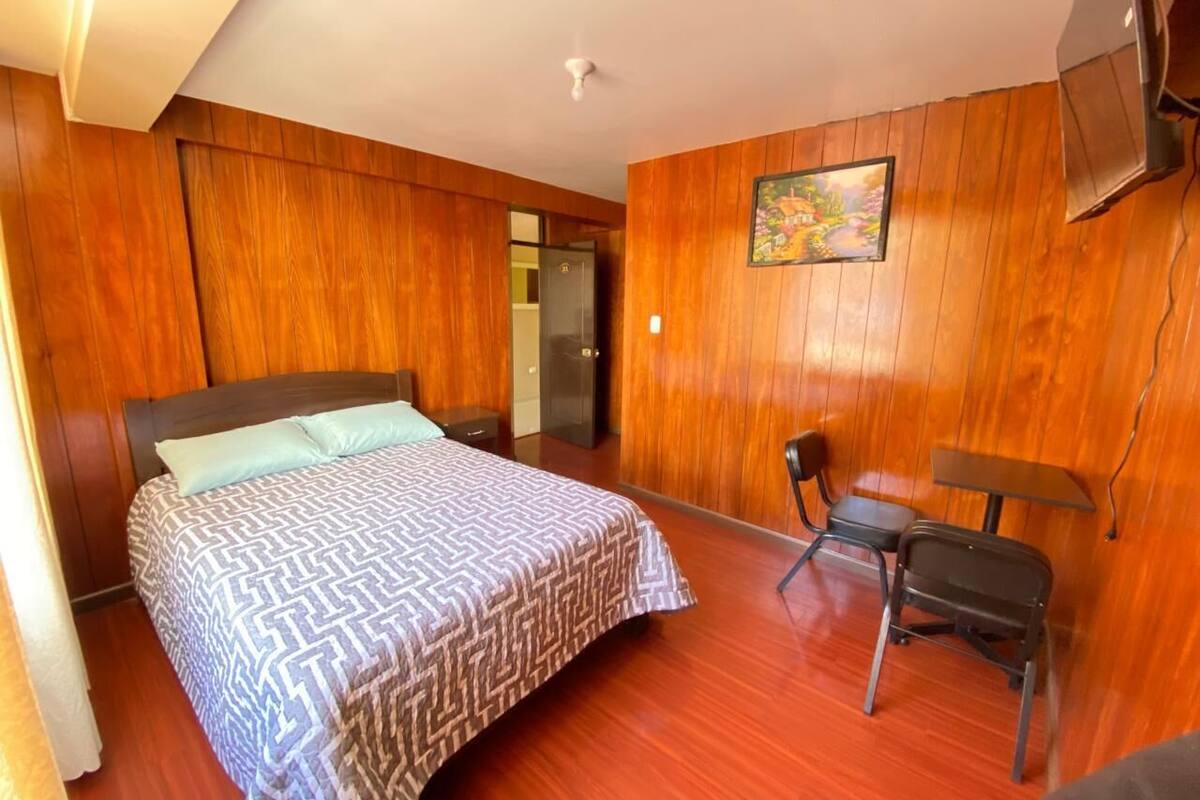 A room with a bed, a desk, and a chair.
