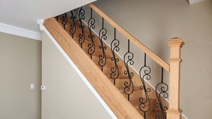A wooden staircase with black metal balusters and a wooden handrail. - Ocean Pearl-Beach block, Quick stroll to Boardwalk (Atlantic City)