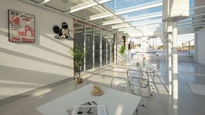 A modern cafe with glass walls, white furniture, and a poster on the wall. - Shanghai MOCOKI hotel (Shanghai)