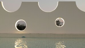 A swimming pool with a unique architectural design featuring circular windows and a tiled floor. - Shanghai MOCOKI hotel (Shanghai)