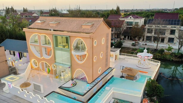 A modern building with a rooftop pool, large windows, and a circular design element. - Shanghai MOCOKI hotel (Shanghai)