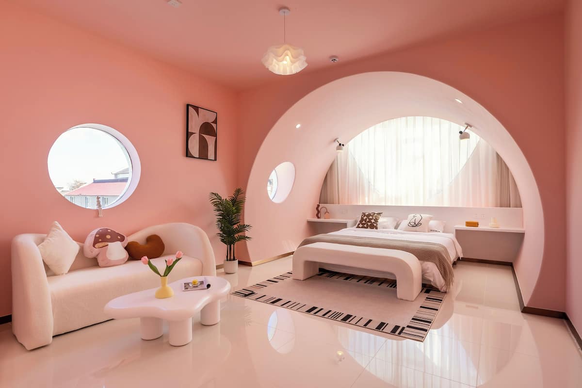 Quarto moderno com uma cama grande, um sofá, uma mesa de centro e um vaso de planta.