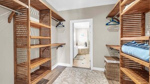 Ein begehbarer Kleiderschrank mit Holzböden und einem gemusterten Teppich.