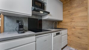 A modern kitchen with a Bosch dishwasher, a microwave, and a coffee maker. - 40m from ski slopes, 2nd floor, fitness, swimming pool, sauna, balcony, fireplace or stove, tv (Les Orres)