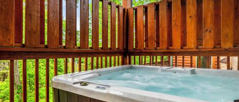 A wooden deck with a hot tub.